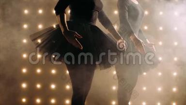 两个穿黑色<strong>芭蕾</strong>舞裙的<strong>芭蕾</strong>舞演员的剪影正在黑暗的工作室里跳<strong>芭蕾</strong>。