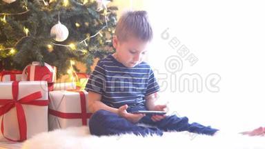 可爱的<strong>小男孩</strong>在圣诞树前用球和灯看动画片。 准备迎接<strong>新年</strong>的孩子