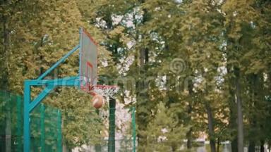 在外面的篮球训练-一个年轻人跳着，扔着一个球，它就进入了目标