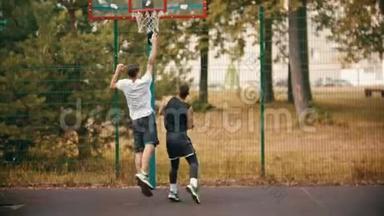 年轻人在运动场上和朋友一起打篮球-运球，避开对手，扔球-