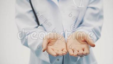 一位快乐的年轻女医生的手`特写。 握着药丸的手在她怀里飞。 长长的黑色美丽的头发