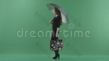 穿着黑色<strong>小裙子</strong>的漂亮女人正站在一把带购物袋的伞下。 她站在一边
