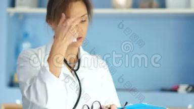 医生女人穿着白色外套和眼镜，手里拿着文件夹。 专业护士、医药和保健