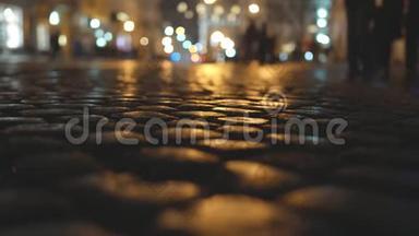城市中的鹅卵石路面在夜间灯光的背景下。 夜间，复制空间
