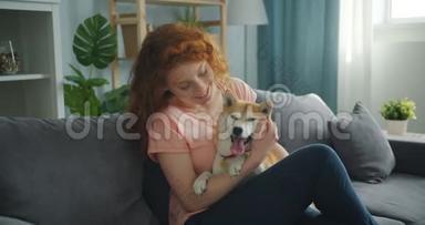 可爱的<strong>宠物主人</strong>和坐在公寓沙发上的可爱的石巴狗说话