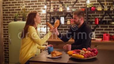 快乐的一对夫妇用牛角面包互相<strong>喂饭</strong>
