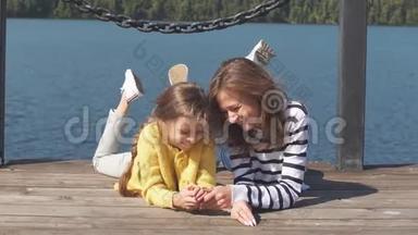 暑假期间，快乐的妈妈和孩子一起躺在码头上