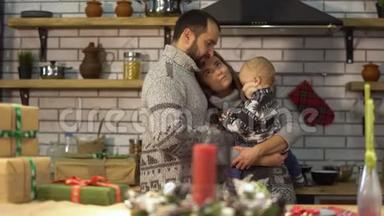 大胡子爸爸穿着温暖的毛衣，在厨房里和小儿子在<strong>妈妈怀里</strong>玩。 男人把胡椒罐给孩子