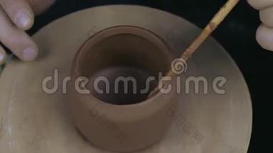陶工在茶壶的边缘涂上油脂，将茶壶固定在茶壶的另一部分。 手工陶土茶壶，用于茶道。