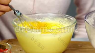 女人用搅拌器打面团，把鸡蛋和糖混在一起