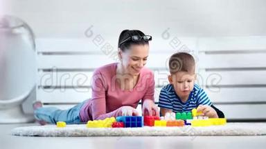 全镜头微笑友好的年轻母亲测试小儿子在家的逻辑思维