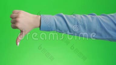 拇指向下在绿色屏幕上签名手势。 不赞成的象征不喜欢消极情绪。