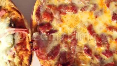 用奶酪、香肠、西红柿、意大利传统食品、垃圾食品将热片的披萨合上。 火腿披萨顶景