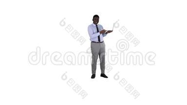 与镜头交谈，年轻的非洲男子手<strong>拿笔</strong>记本电脑在白色背景。