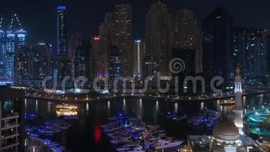 迪拜的游艇码头，旁边是Al Rahim清真寺、住宅塔和摩天大楼，鸟瞰夜景