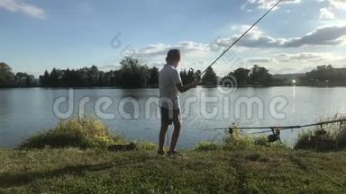 在湖边钓鱼的男孩。 美丽的鱼塘巴丁附近，班斯卡比斯特里察，斯洛伐克。 捕鱼的地方。 阳光照耀着鱼塘