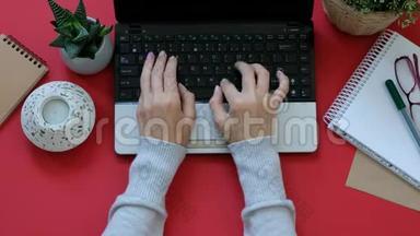 女士`双手在现代红色办公桌上的<strong>笔记本</strong>电脑上工作，从<strong>上面</strong>可以看到