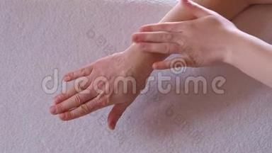 一个女人的特写`她的手在她的<strong>手腕</strong>上测试冷却凝胶。 在他<strong>手腕</strong>上涂止痛霜，按摩。