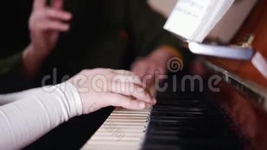 音乐课。 女孩弹<strong>钢琴</strong>，年长的老师坐在附近和女孩一起玩。 右侧视图