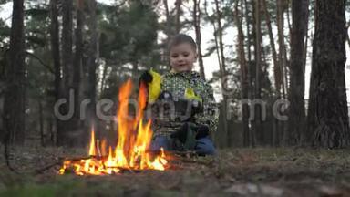 男孩盯着壁炉。 纵火背景。 漂亮的孩子在火里热身。 当战争来到家乡的时候。 难民