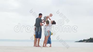 夫妻，可爱的年轻夫妇和他们的三个孩子在白沙滩上，家庭旅行，幸福的家庭度假