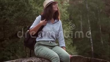 女旅行者在<strong>森林</strong>里休息。 一位戴着帽子的年轻女<strong>游客</strong>的肖像