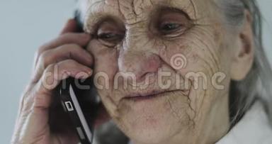 一位<strong>满脸皱纹</strong>的祖母在手机上说话。