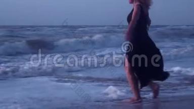 女人逃离海浪，大海的泡沫，在沙滩上<strong>刮风</strong>