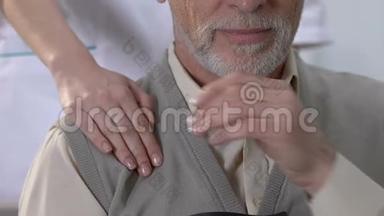 护士把手放在伤心的老人的肩膀上，支持病人康复