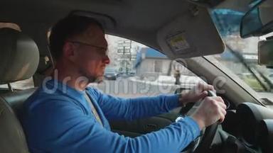 白色司机穿着蓝色衬衫驾驶汽车<strong>保护眼睛</strong>免受阳光与汽车遮阳延长。 冬天的午后。