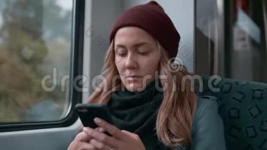 年轻的白种人女孩戴着红帽子乘坐<strong>地铁</strong>或电车，使用<strong>电话</strong>，打印信息。 慢动作