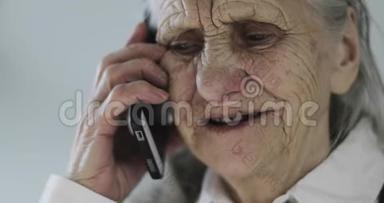 一位<strong>满脸皱纹</strong>的老妇人在办公室里用手机说话。