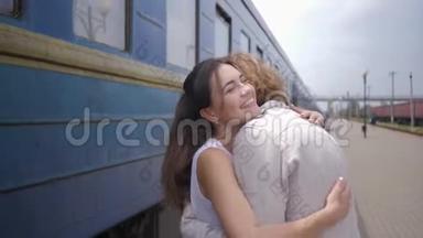 幸福的年轻女子拥抱男人，分离后在火车站的火车车厢旁欢笑