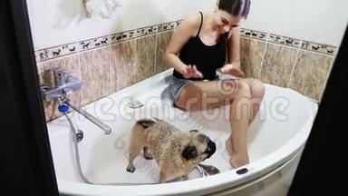 洗狗狗。 女人给可爱的小狗洗澡。 湿狗狗在发抖