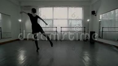 穿着黑色紧身裤的年轻芭蕾舞演员在白色舞蹈课上一个接一个地做芭蕾动作。 芭蕾舞演员