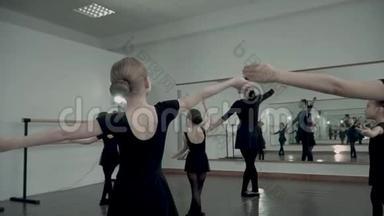 在芭蕾舞工作室里模仿舞蹈动作的小芭蕾舞演员。