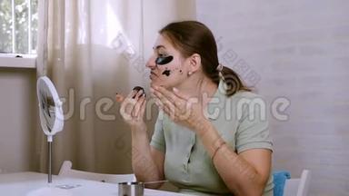 美颜护肤.. 女人在脸上涂眼底补丁。 洗面膜。 使用天然咖啡面罩，面部护理