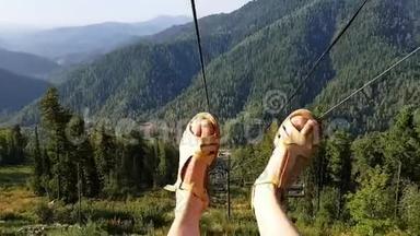 女孩乘坐缆车，美丽的全景和调皮的舞蹈脚。 度假的乐趣。 山景