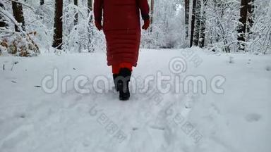 在<strong>冬季度假胜地</strong>附近的白雪覆盖的森林中慢慢行走的人，后景