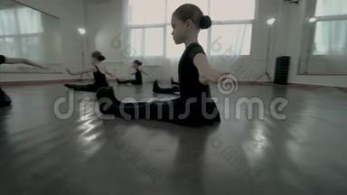 小舞者坐在地板上，双脚伸直，双手放在一边