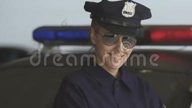 戴着帽子和太阳镜的友好巡逻妇女对着相机微笑，法律保护
