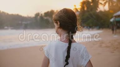 令人惊叹的后景拍摄快乐宁静的小6-8岁的<strong>女孩子</strong>站在阳光明媚的热带日落海滩。
