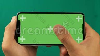 乌克兰基辅-2019年11月23日：关门人手中拿着一部带有绿色屏幕色度键的智能手机