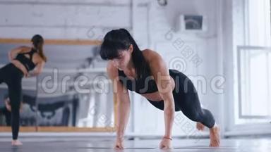 运动的女人在交叉健身馆做俯卧撑。 女人<strong>训练</strong>她的身体和<strong>手臂</strong>。 交叉<strong>训练</strong>。 女运动员
