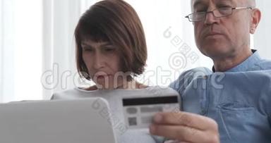 一对老夫妇在家用笔记本电脑上网购物