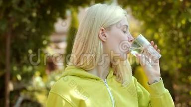 玻璃水的女人的面部肖像。 年轻女子喝水。 把金发女孩的画像贴起来。 清洁卫生