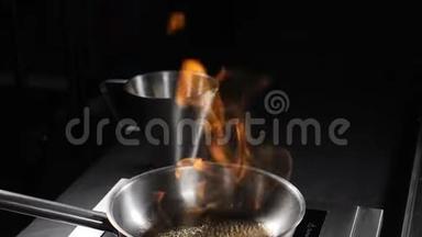 煎锅上方大火焰的慢动作视图。闭合。油和酒精用明火点燃。高清拍摄