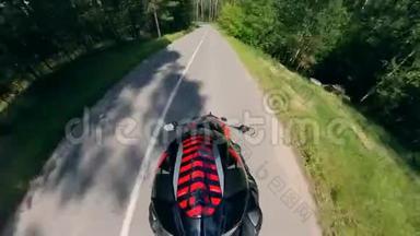 骑在森林道路上的摩托车手的俯视图.. 摩托车在路上。