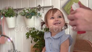幸福的一家人在厨房里，女儿上，爸爸充气肥皂泡。