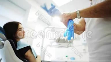 一个十几岁的女病人在等牙医，牙医在给她戴乳胶手套